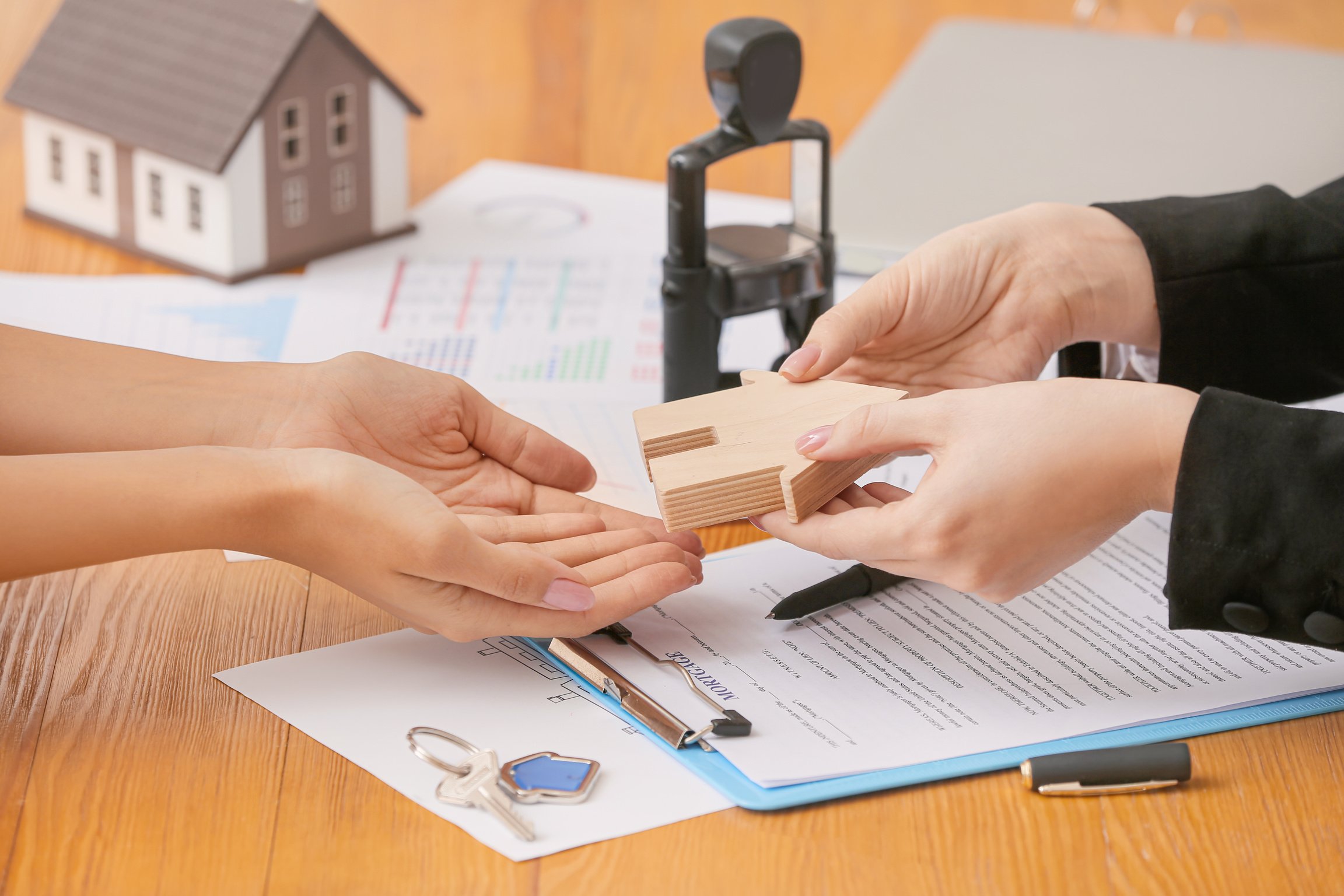 Real Estate Agent and Client with Model of House